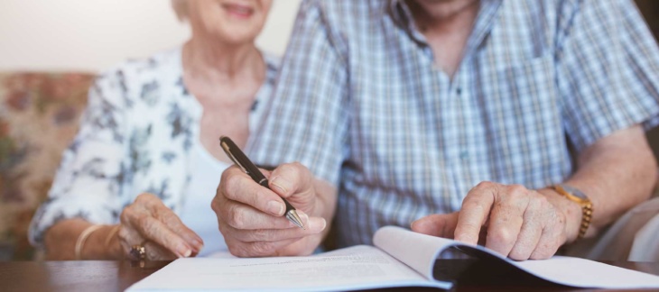 Older couple going over documents with pen in hand