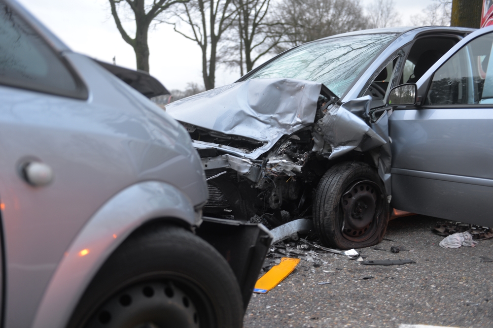 Two cars involved in a head-on collision on a highway, illustrating the severe impact of a front-end crash.