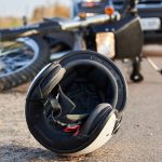 Photo of car, helmet and motorcycle on road, the concept of road accidents.